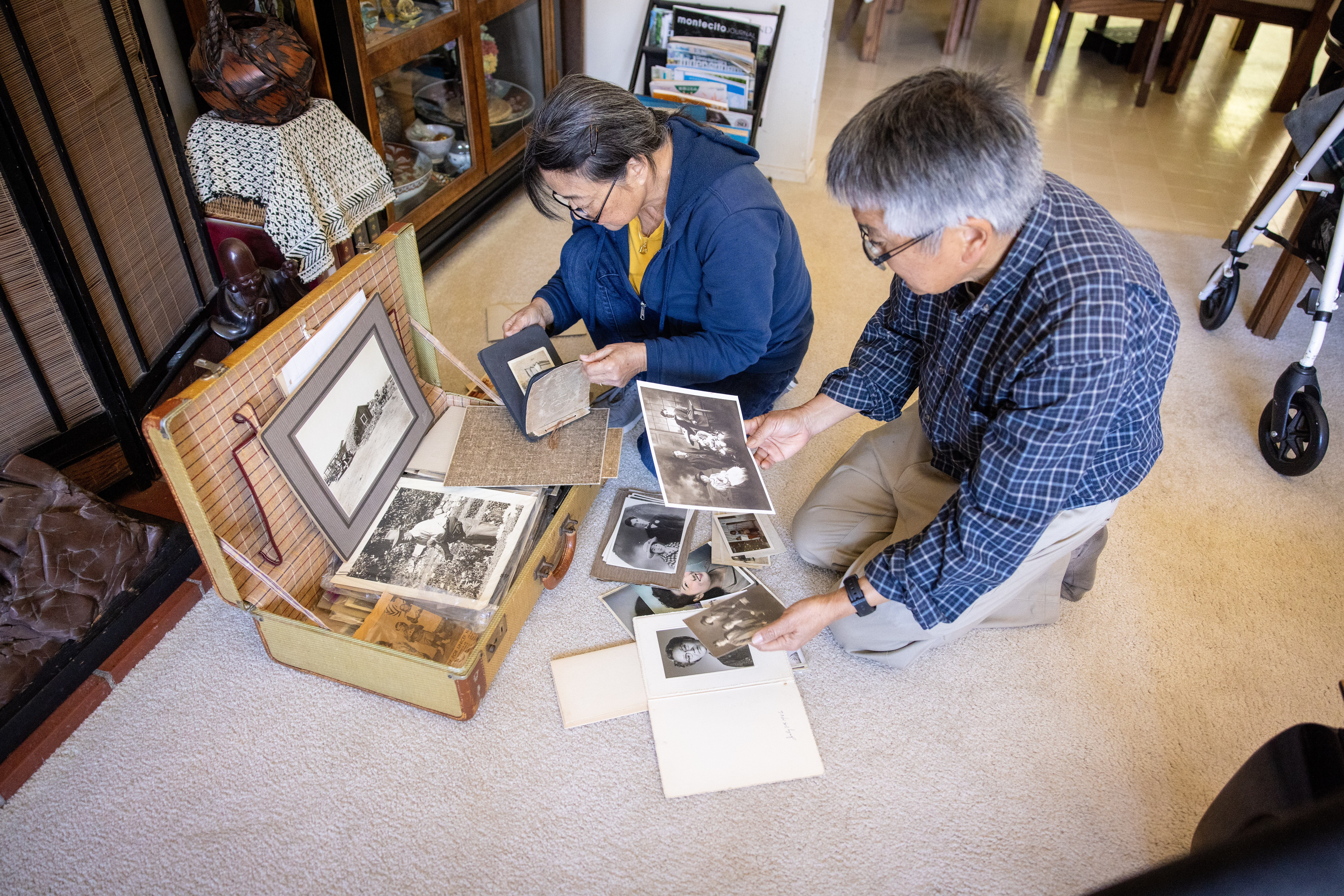 Paul and cousin Roberta Fujii Cook look through family photos stored in the suitcase Paul’s aunt took to the camp.