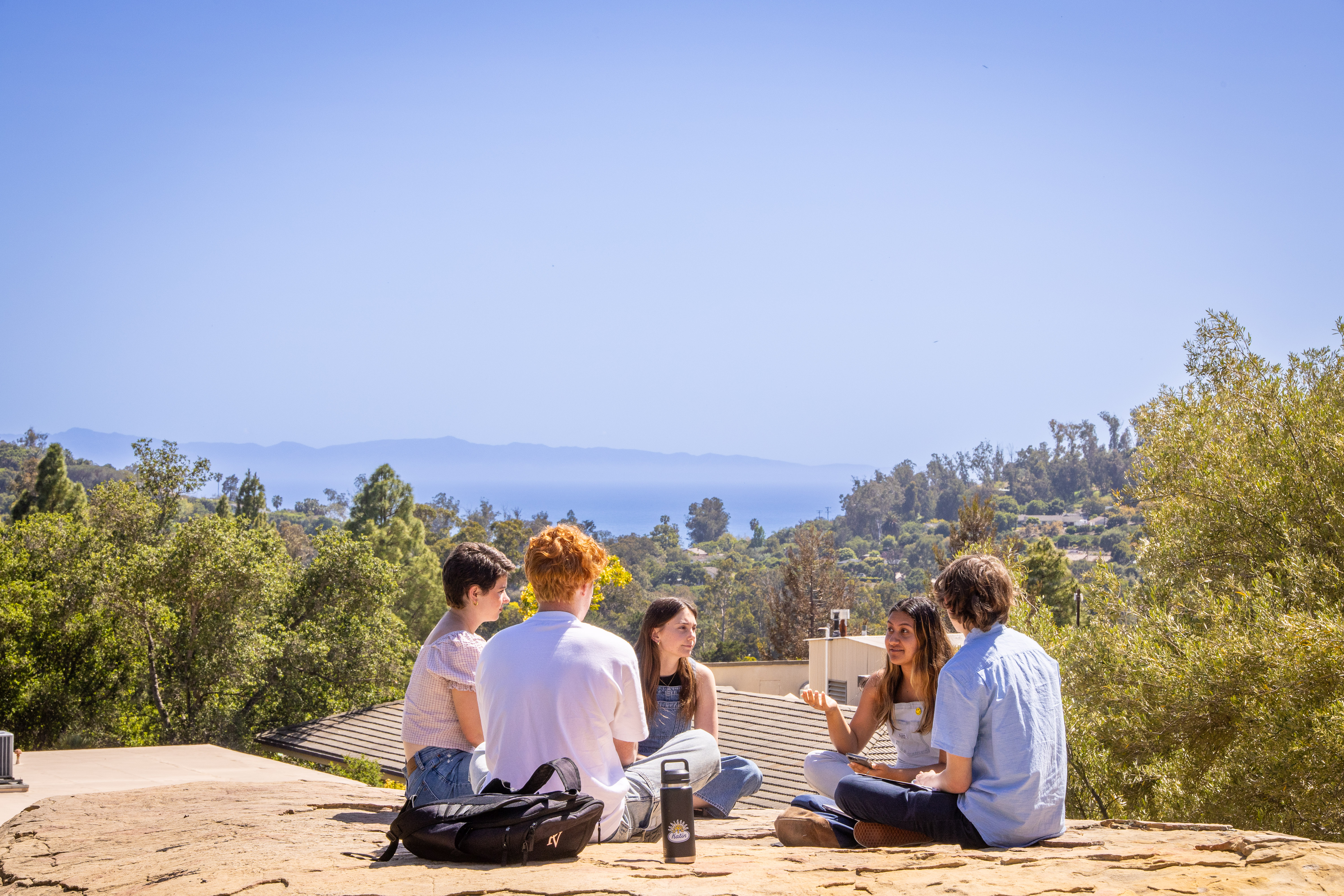 students sitting on a rock first year page