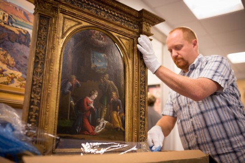 Chris Rupp, collections manager of Westmont Museum of Art, carefully uncrates Tisi's "La Nativité" 