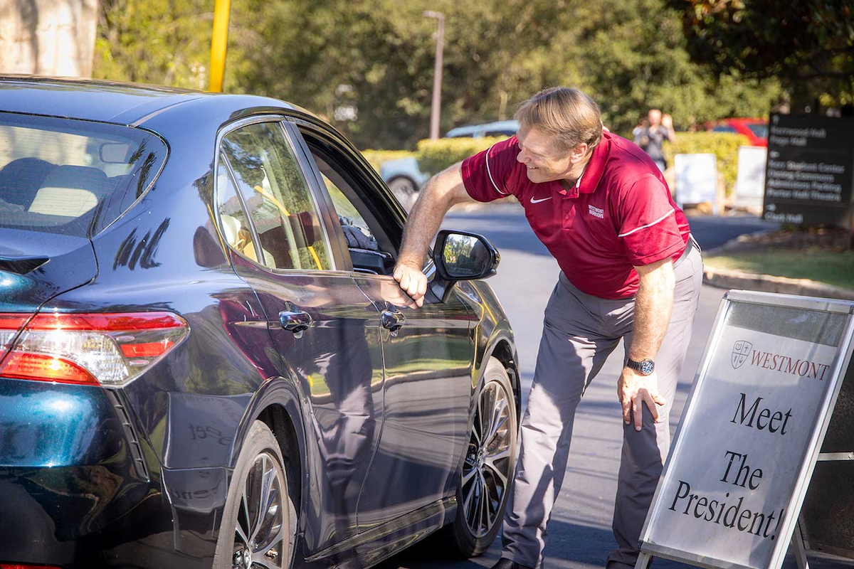 President Beebe greeting students through their car windows.