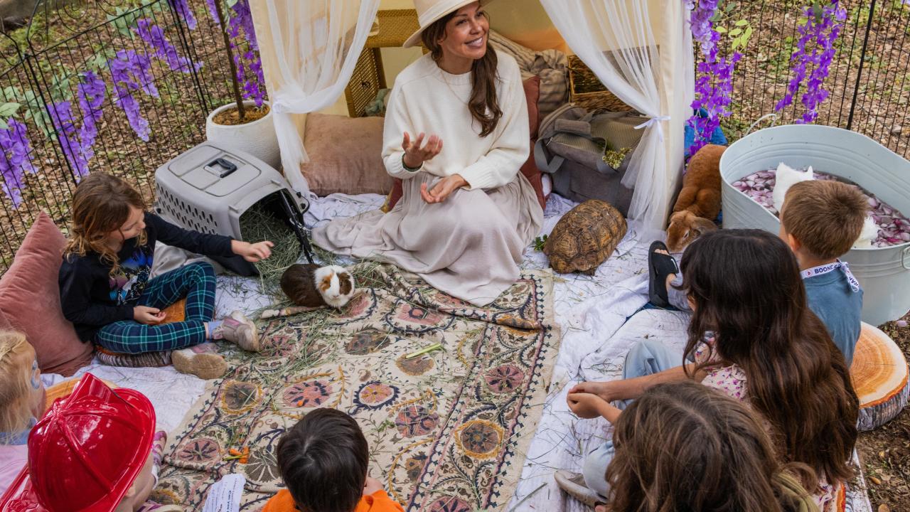 Jade Hawkins of The Smallest Little Farm sitting with children and small animals.