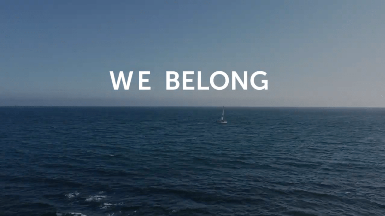 We belong text over the ocean.
