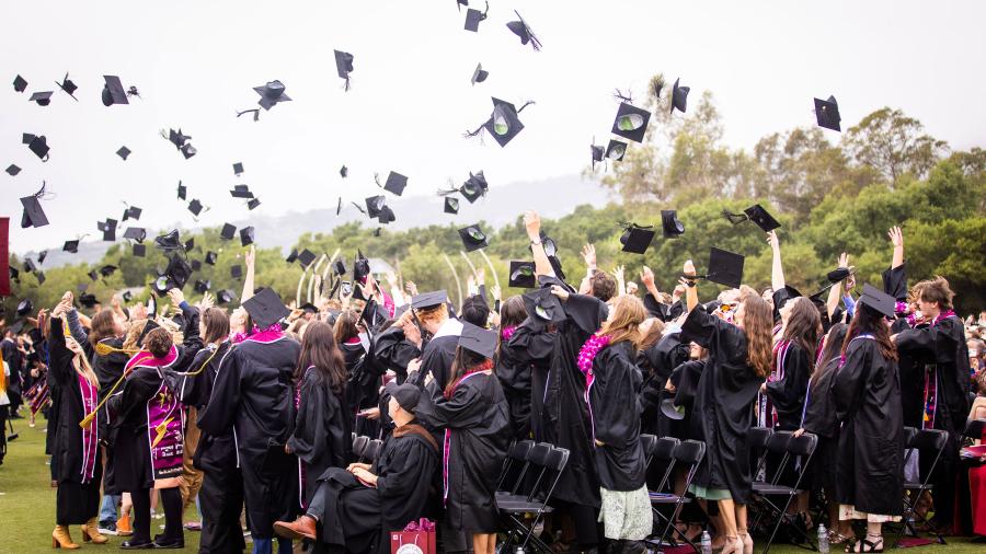 Graduates toss their mortarboards to the sky