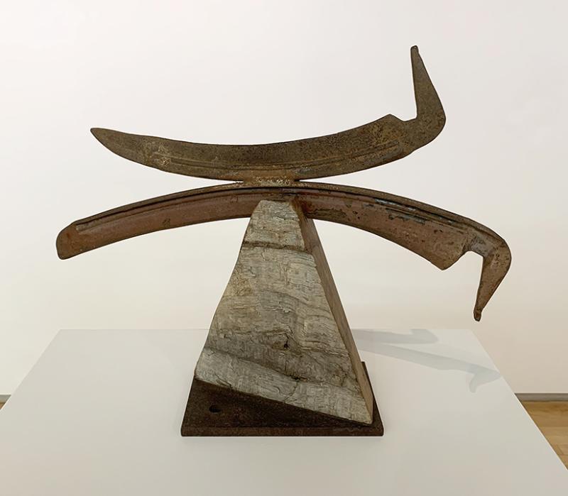 sculpture with scyth and stone