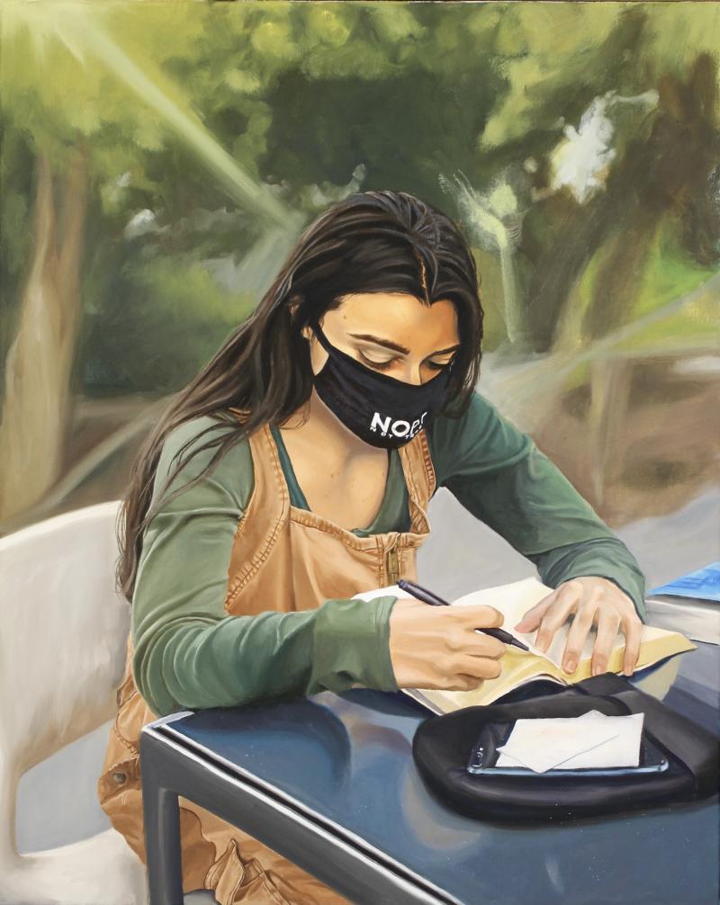 girl with mask studying at an outdoor table