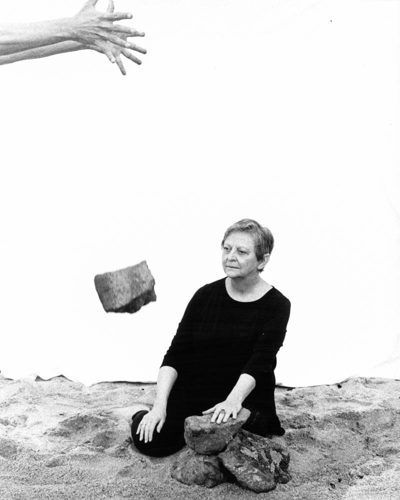photo with hand dropping stone in front of figure
