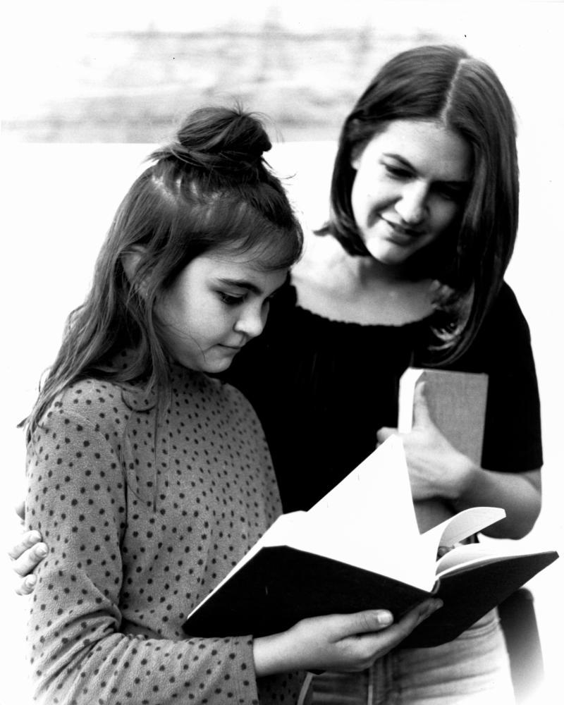 photo of two figures reading a book