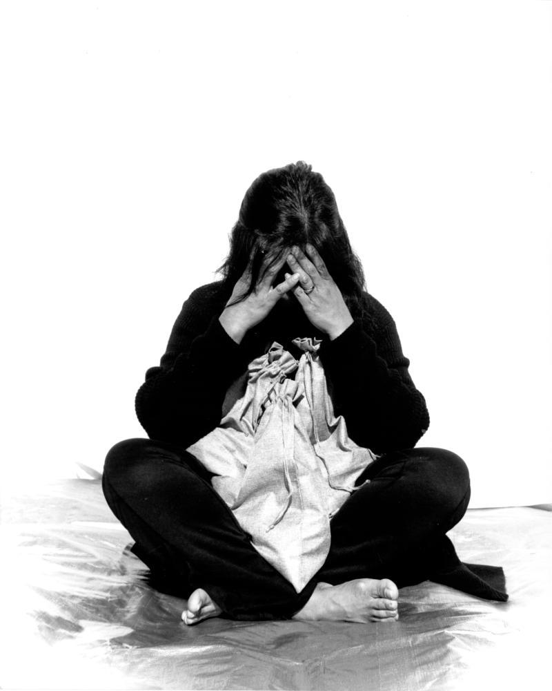 figure sitting with hands over face