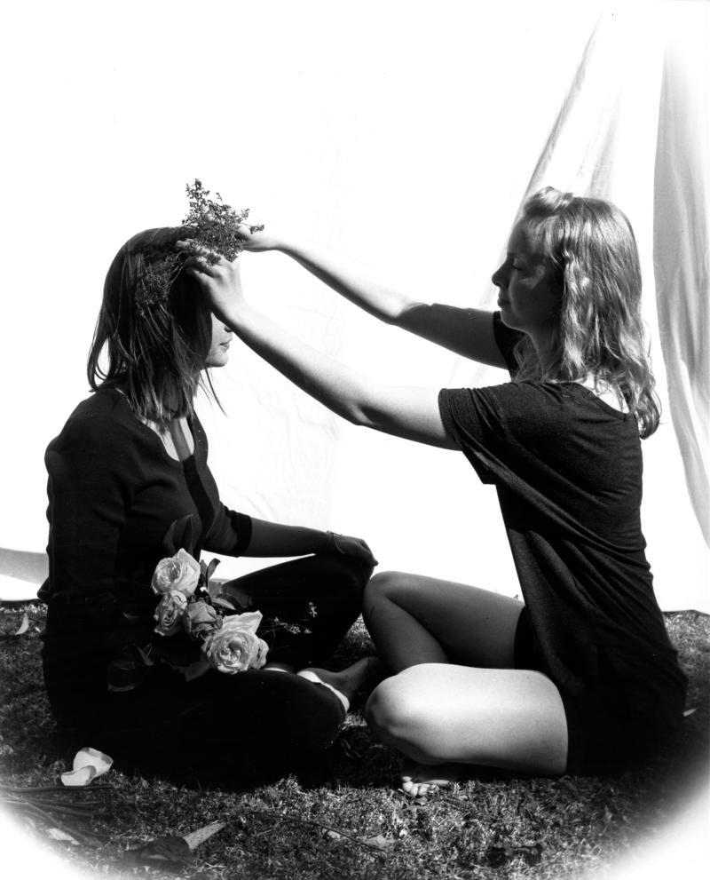 photo of figure putting a flower crown on another figure