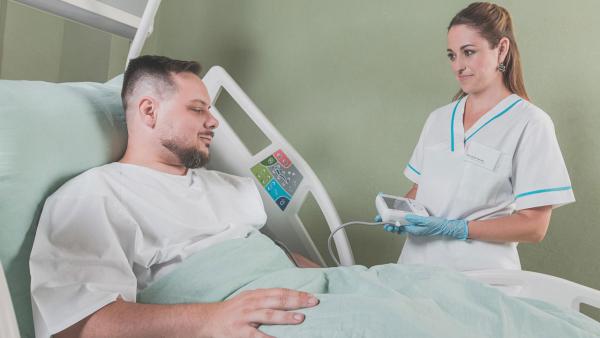 A nurse stands next to a patient in the hospital