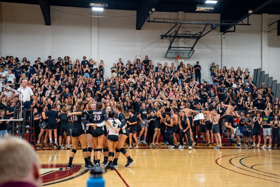 Women's volleyball celebrates during a blackout game