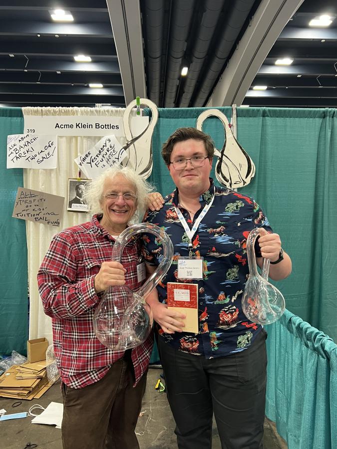 Evan Grahn (right) holds a Klein bottle, an object with only one surface, one hole and no edge.