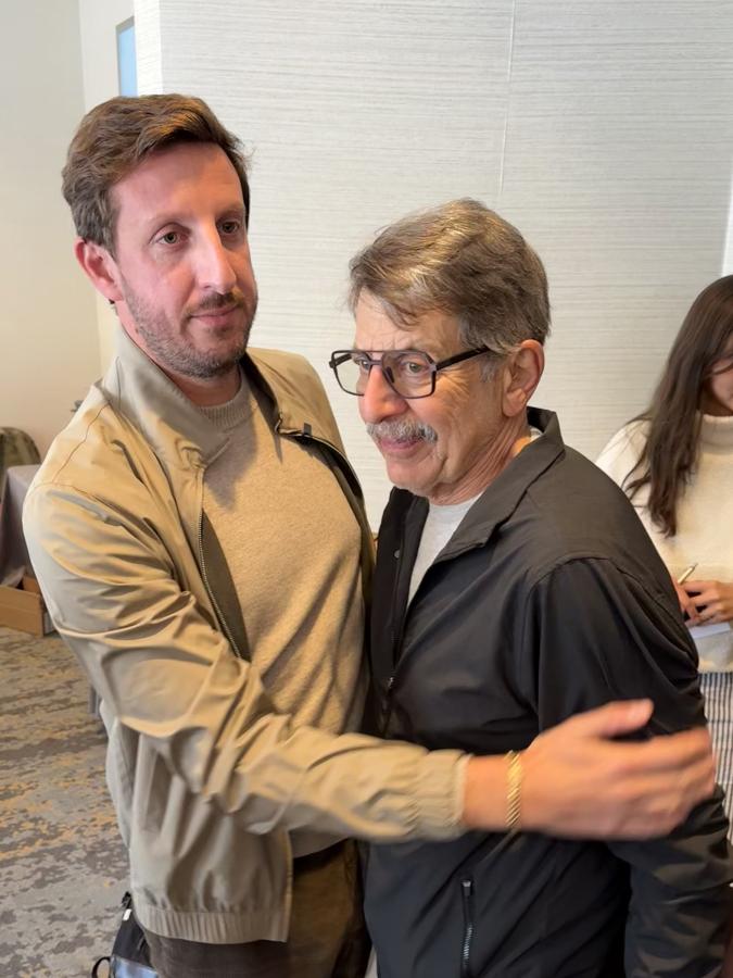 Zack hugs his father in the lobby following the standing ovation